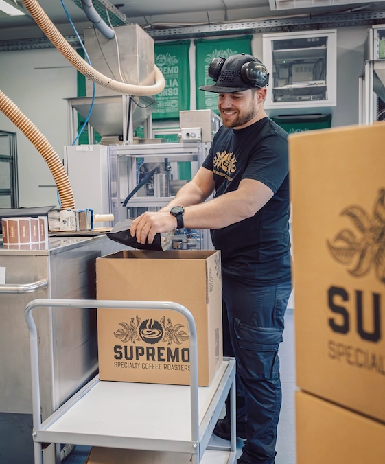 Produktionsarbeiter verpackt Kaffee in Karton