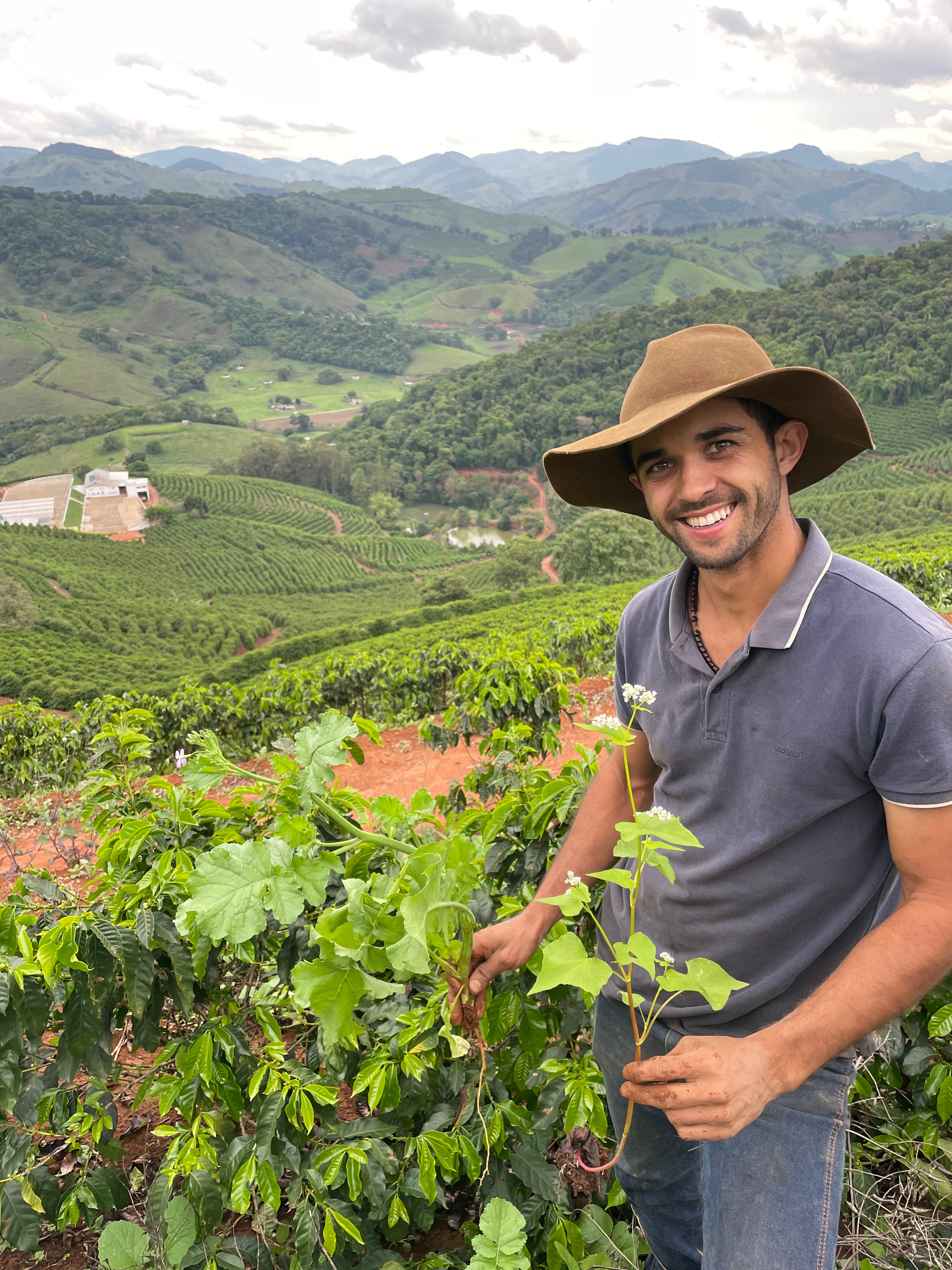 Antonio Marcio da Silva zeigt, dass zwischen den Kaffeepflanzen auch andere Pflanzen wachsen, um Biodiversität auf der Farm zu schaffen. Dadurch kann er den Gebrauch von Düngemitteln reduzieren. Sítio Baixadão, Brasilien | SUPREMO Coffee