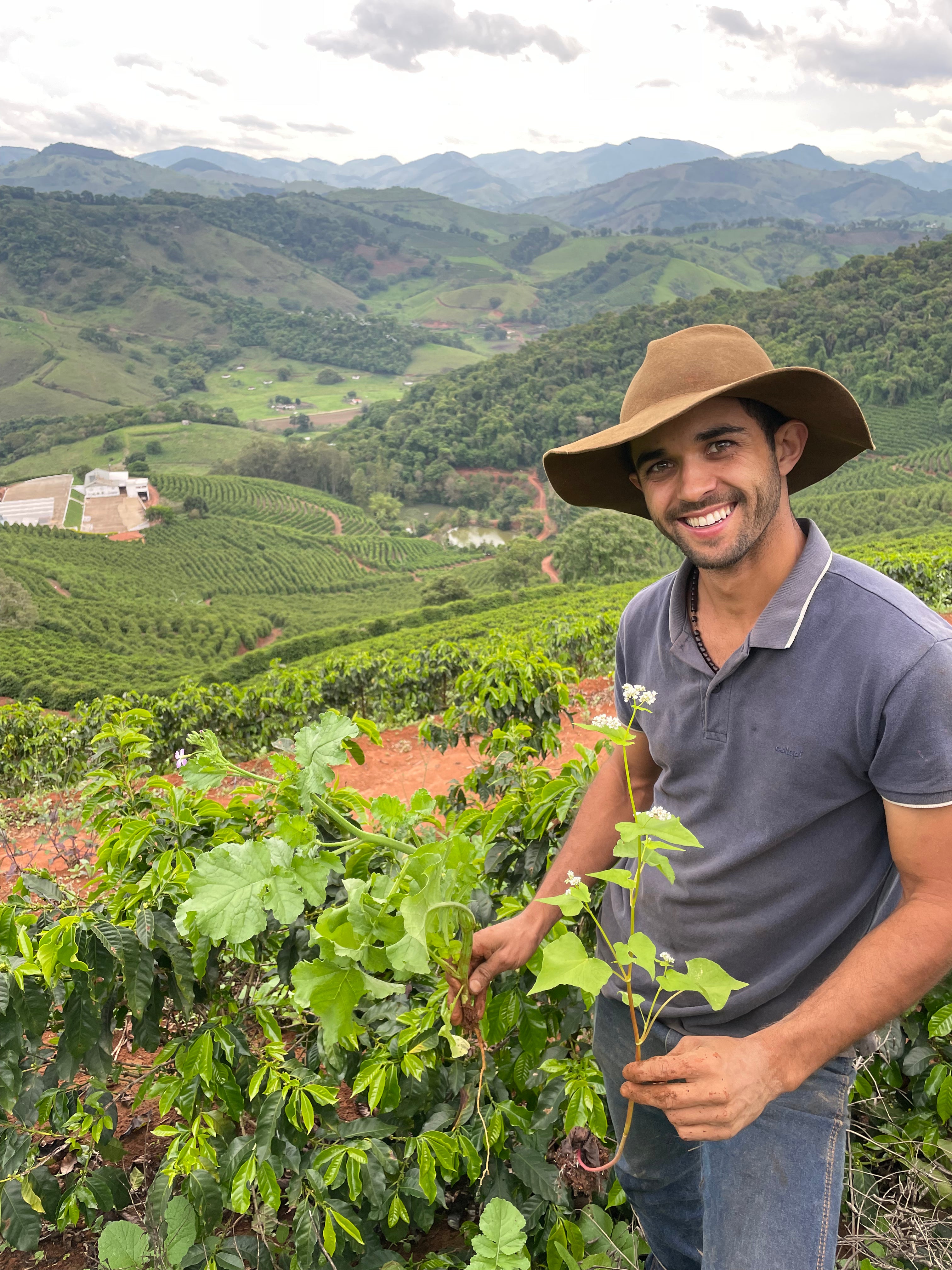 Antonio Marcio da Silva zeigt, dass zwischen den Kaffeepflanzen auch andere Pflanzen wachsen, um Biodiversität auf der Farm zu schaffen. Dadurch kann er den Gebrauch von Düngemitteln reduzieren. Sítio Baixadão, Brasilien | SUPREMO Coffee