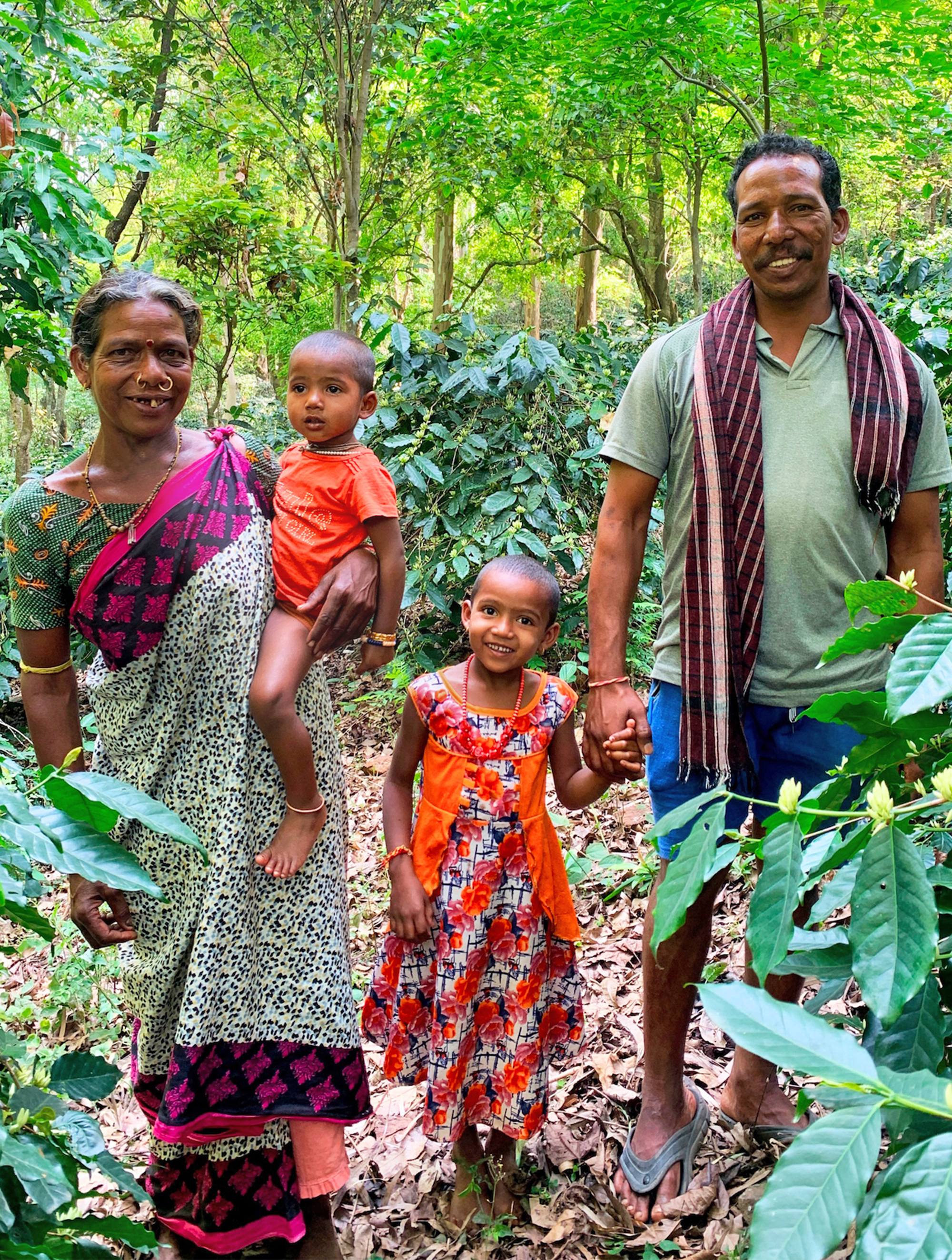 Musiri Familie in Wald umgeben von Kaffeebäumen